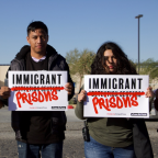 Three people hold up signs reading, Immigrant Prisons