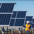 Worker standing by solar panels