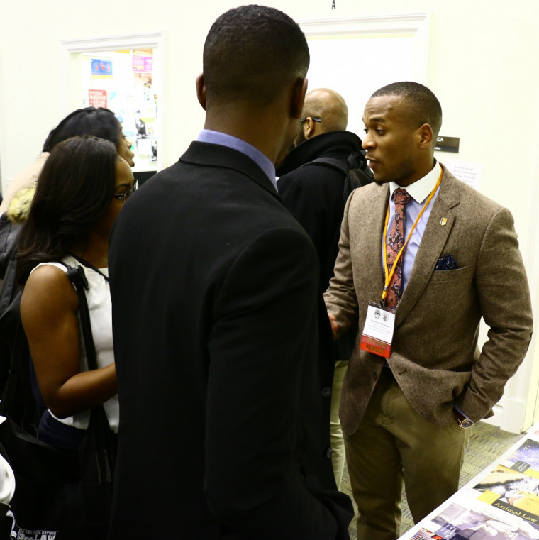 SBA President Lawrence Pittman '18, talks to potential students at a recruiting event