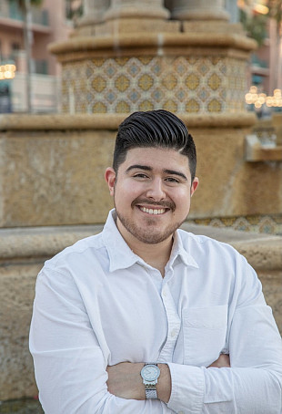 Michael smiling at the camera. He is wearing a white button-up shirt.