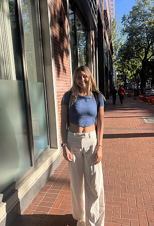 Bailey smiling outside, wearing a blue crop top.
