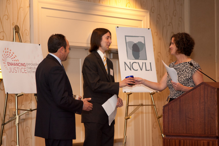 Law Student Matthew Merryman accepts NCVLI's Volunteer of the Year Award from NCVLI Executive Director Meg Garvin.