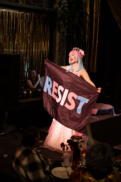 Billie McBride holds a RESIST flag.