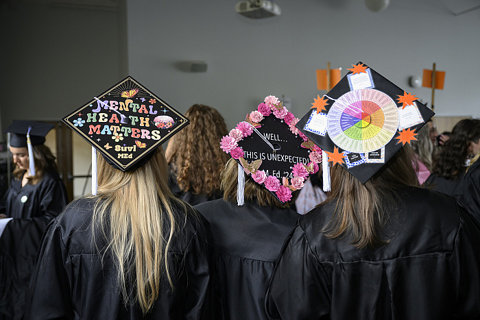 Graduates with decorated mortarboards.