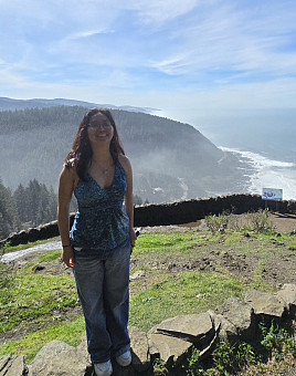 2025 GEM Mentor, Alondra. Alondra is outside, on a cliff. In the background is a large body of water, blue skies with some cloud.