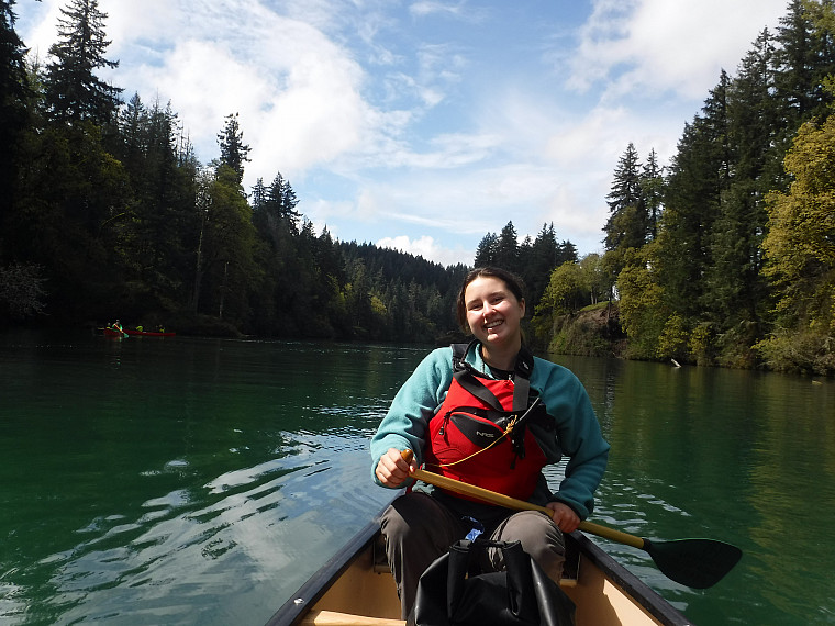 A student steers a canoe and smiles Estacada Lake