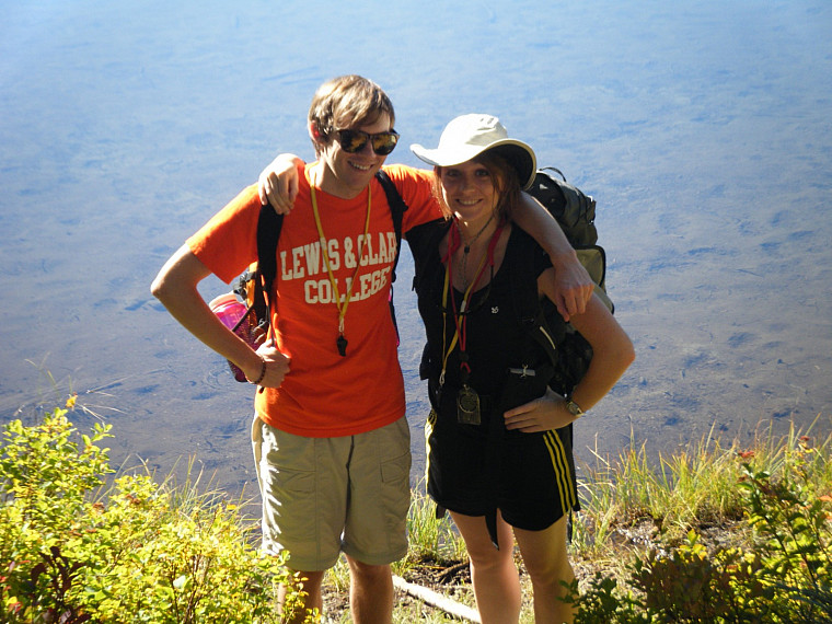 two students stand in front of a lake in Indian Heaven
