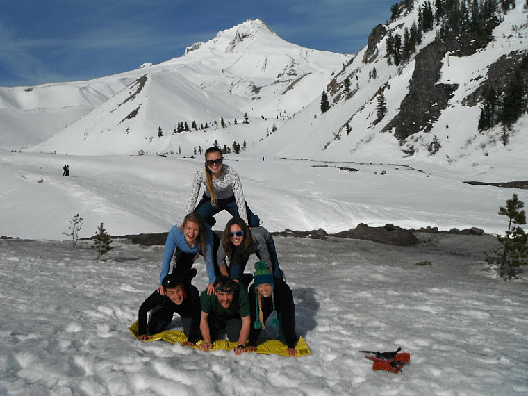 Students make a pyramid in front of a snowy landscape