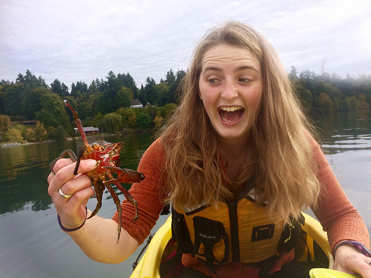 A student holds a crab on a boat