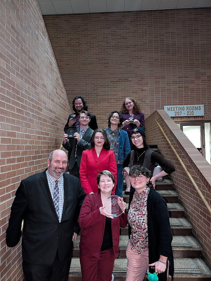 The L&C team and coaches on a staircase