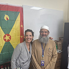 Dr. Emily Talkington with Dr. Bhaiyat in front of Grenadian flag.