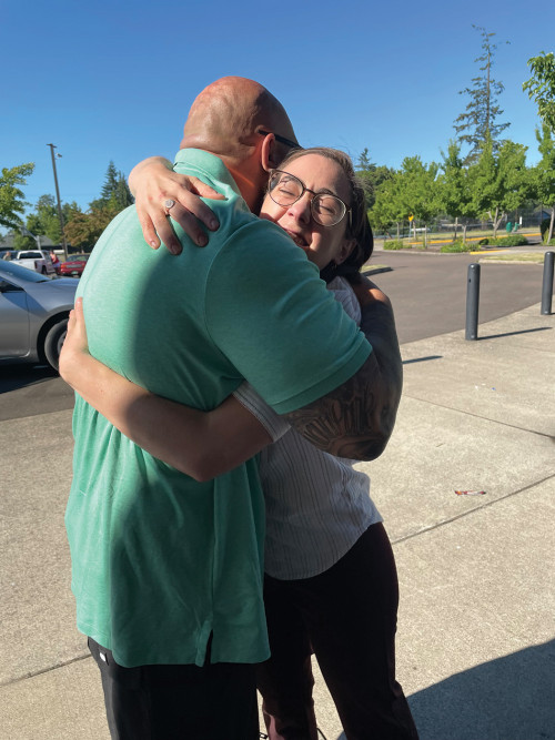 CJRC student Maggie Powers ?21 gets a hug from her client Ronnie Allen, who received a commutatio...