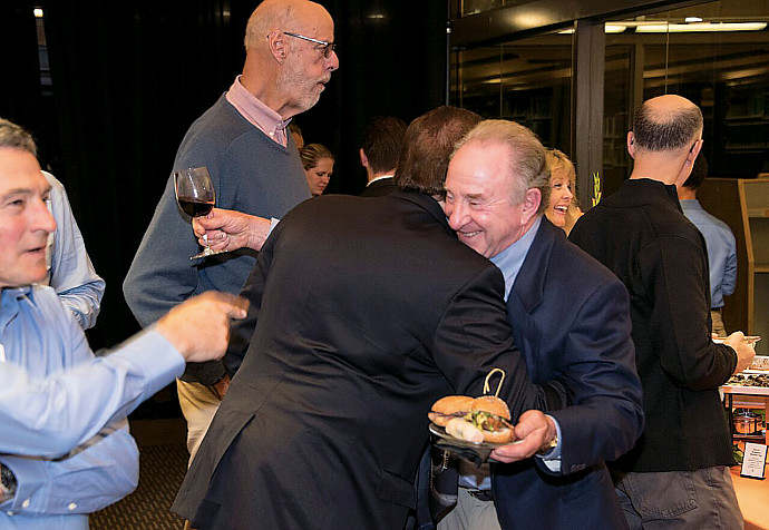 Board of Visitors President Mark Tratos '79 (left) greets fellow member Monte Bricker.