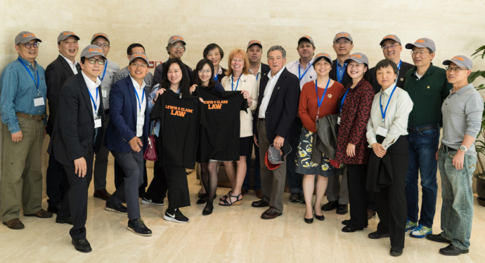 The alumni reunion group pose with Lewis &amp; ?Clark Law School swag.