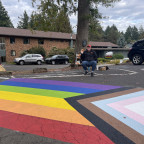 Image of a rainbow LGBTQ+ flag painted on a crosswalk.