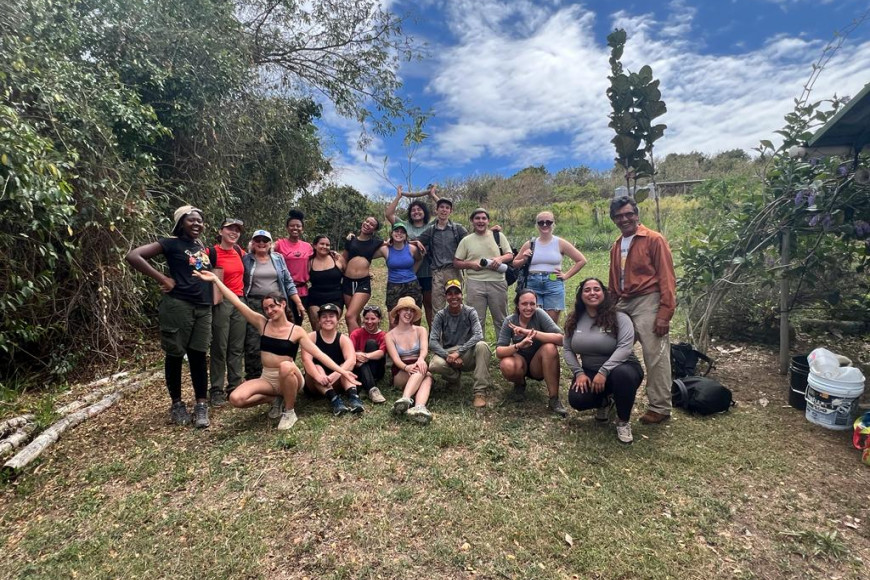 The entire volunteer group poses for a picture with partners from Project YUCAE after planting 50 trees on their community farm.