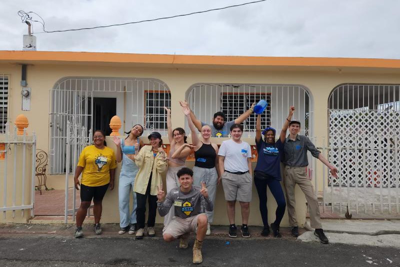 Volunteers and program leaders posed with partners from SBP in front of a house that they were helping to repair after it was damaged by ...