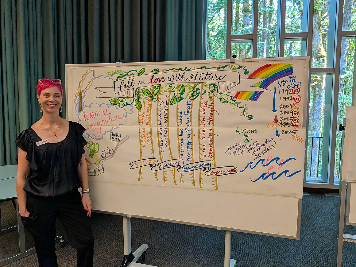 Artist Molly Chidsey stands beside Fall in Love with the Future, a live visual illustration capturing participants' collective visions fo...