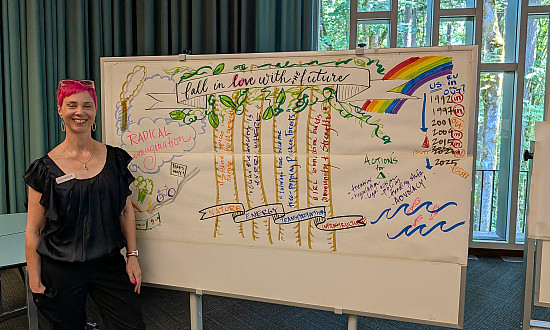 Artist Molly Chidsey stands beside Fall in Love with the Future, a live visual illustration capturing participants' collective visions fo...