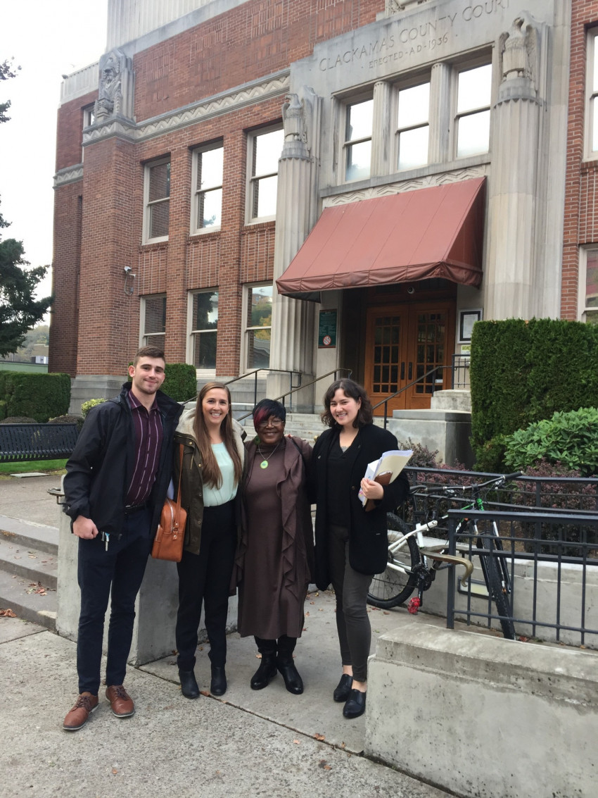Clinic students Maya Rinta and Marina Spencer and intern Miles Cohen with client outside Clackama...