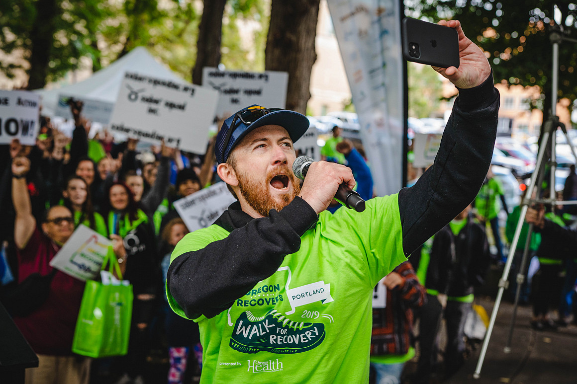 Andrew Swanson, JD '24, leads the crowds at a past Walk for Recovery.