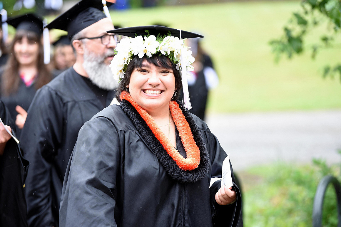 A graduate student smiles at commencement.