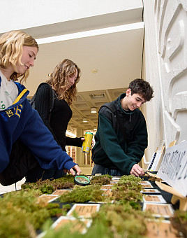 Students look at moss samples in Watzek Library during Moss Week 2025