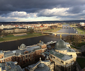 Cityscape image showing buildings and a river running through the city.