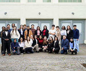 A large group of students pose together outside.