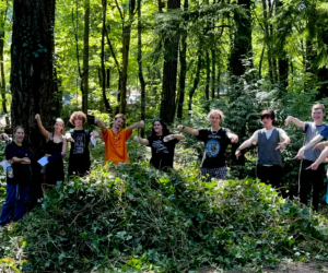 Students posing in front of a large pile of ivy that they pulled.
