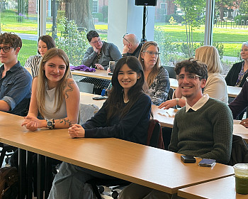 Three students sit at a table.