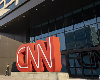 A businesswoman walks towards the entrance to the CNN Center in Atlanta, Georgia, the world headquarters of the Cable News Network, in the m