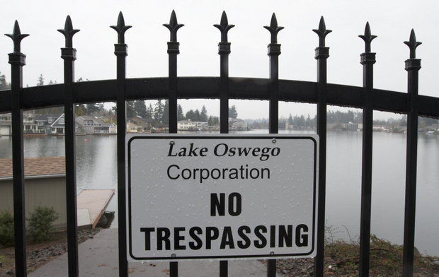 A sign indicates restricted access to Oswego Lake in Lake Oswego.