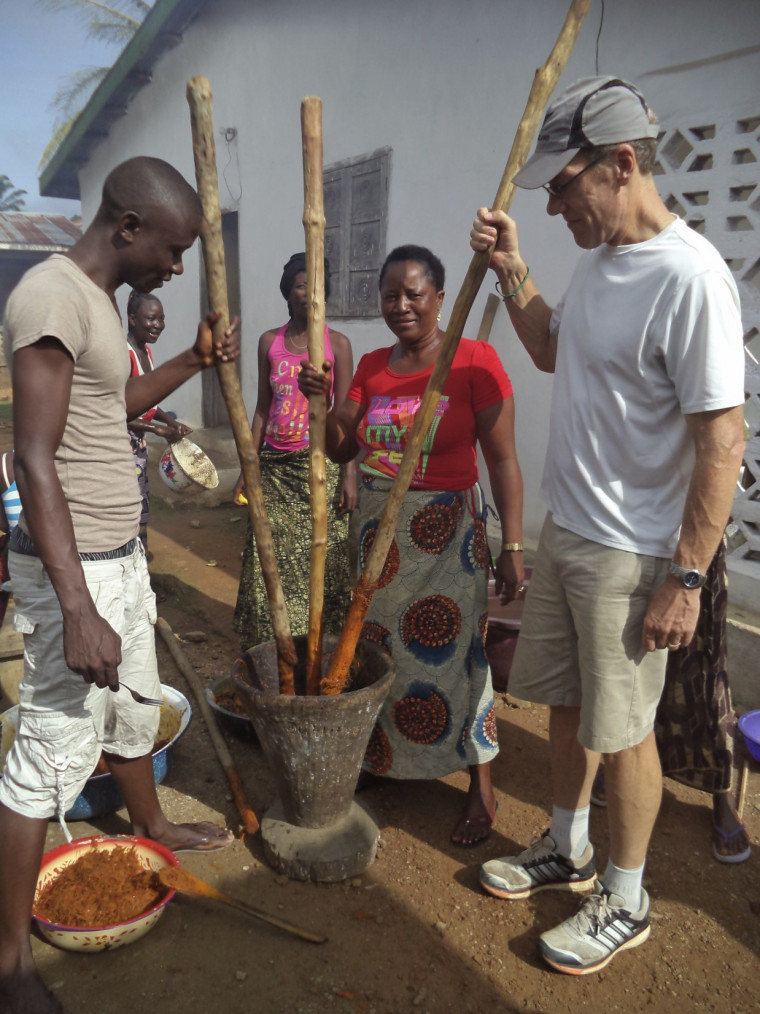 Professor Dan Rohlf pounding palm oil seeds in Sierra Leone.