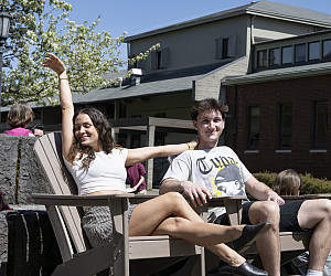Students lounging outside in the sun on campus.